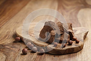Chunks of gianduja with hazelnuts on wood board