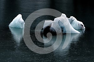 Chunks of ice flow in Glacier Bay Alaska creating brilliant reflections