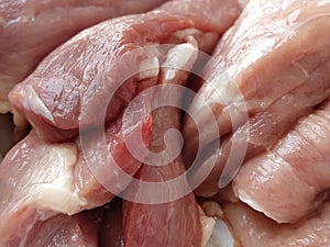 Chunks of meat. Raw pork. Fine veins and texture of the meat. Pink meat with darker red areas. Fresh meat products for sale.