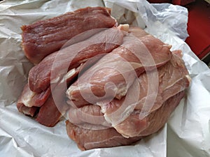 Chunks of meat. Raw pork. Fine veins and texture of the meat. Pink meat with darker red areas. Fresh meat products for sale.