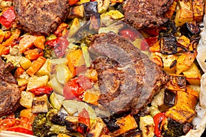 Chunks of pork baked on a baking sheet in the oven with spiced potatoes, bell peppers, zucchini, pumpkin and broccoli. Homemade