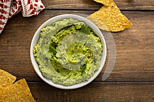 Chunky homemade guacamole in a bowl with tortilla chips