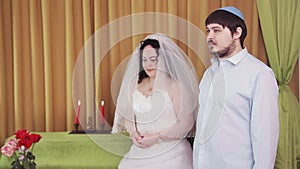 During the chuppah ceremony, the Jewish bride and groom in the synagogue, the bride and groom stand looking at each