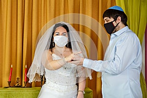 During a chuppah ceremony at a Jewish wedding in a synagogue, the groom puts a ring on the bride& x27;s index finger of a