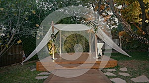 a chuppah decorated with lamps and flowers standing in the garden.