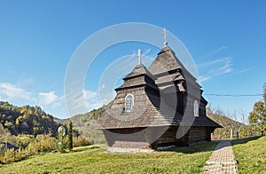 Church of the Archangel Michael Old wooden building in mountains. wonderful sunny autumn weather. trees in fall foliage. cloudless