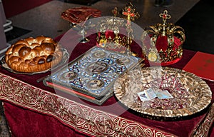 Church attributes for wedding ceremony. Gold crowns are on the altar. Church book Gospel