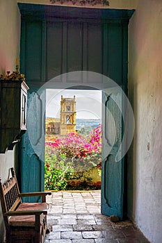 Church of Barichara framed by the door of old colonial house in Satander, Colombia