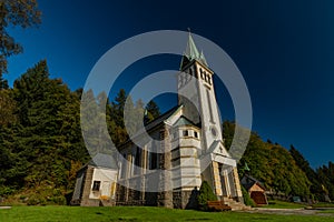 Church in Bedrichov village in autumn sunny evening with sunset light