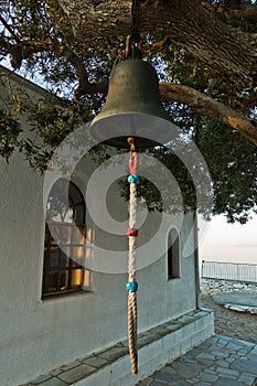 Church bell in front of Agios Ioannis Kastri church at sunset, famous from Mamma Mia movie scenes, Skopelos Island