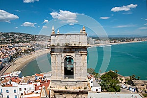 A church bell tower with a mediterranean view behind.