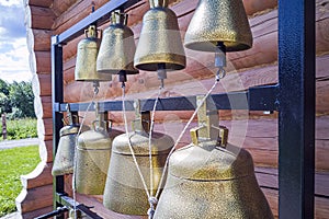 Church bells in monastery. Bell tower with eight bells outdoors near wooden countryside church