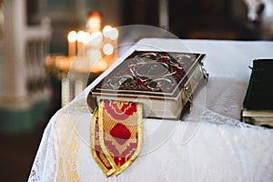 Church book on white tablecloth with candals