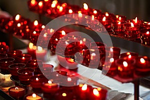 Church candles in red chandeliers