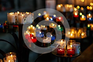 Church candles in red, green, blue and yellow transparent chandeliers