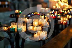 Church candles in red, green, blue and yellow transparent chandeliers