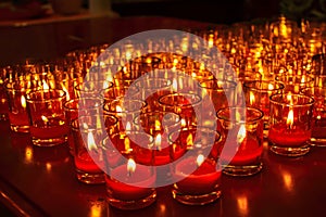 Church candles in red transparent chandeliers