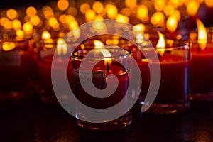 Church candles in red transparent chandeliers