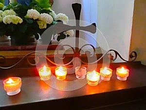 Church candles in red and yellow transparent chandeliers