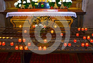 Church candles in red and yellow transparent chandeliers