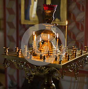 Church candles in red and yellow transparent chandeliers