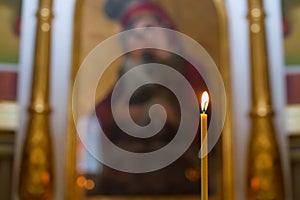 Church candles standing in the temple on the stand during the service.