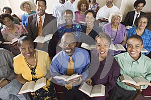 Church congregation sitting on church pews with Bible portrait high angle view