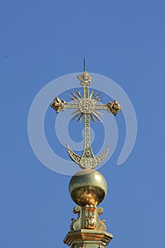 Church cross in gold color. Christian faith. Religious building, building for the worship of God