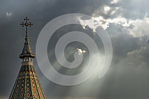 Church cross and storm clouds with light rays. Apocalypse background. Halloween concept. photo