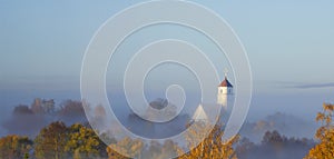 Church at dawn in the fog. Autumn landscape. Early morning in the village