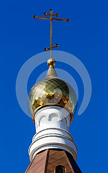 Church dome with a cross against, blue sky