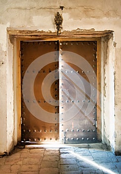 The church door almost close with light rays falling down to the