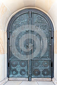 Church door with relief of Archangelo-Mikhailovsky Zverinetsky monastery in Kyiv, Ukraine