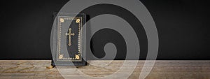 Church faith Christian background banner panorama - Old holy bible with golden cross on old rustic vintage wooden table and black