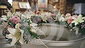 Church font decorated with flowers for infant baptism.