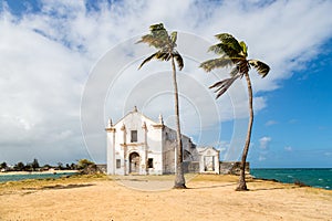 Iglesia a fortaleza de sobre el isla dos palmera árboles sobre el arena. indio Océano Costa provincia 
