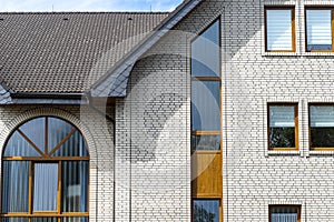 The church has a classic facade of white brick and a conical roof, visible semicircular and rectangular window.