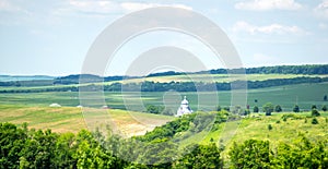 Church among hills and fields in summer in Ukraine