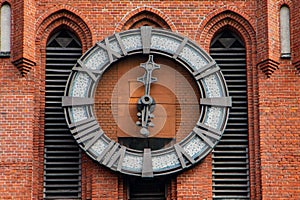 Church of Holy Family. Magnificent Catholic church of early 20th century. Fragment of building. Close-up of clock on tower