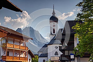 Church and houses of Garmisch with Zugspitze peak in Bavaria