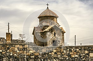 Church of Karmravor in honor of the Blessed Virgin Mary behind a stone fence in the city of Ashtarak