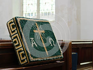 Church kneeler on wooden pew, for Christian prayer.