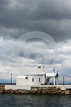 A church next to the sea under a cloudy sky