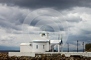 A church next to the sea under a cloudy sky