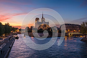 Church of Notre Dame de Paris in France before burning fire at sunset on river Seine reflecting lights