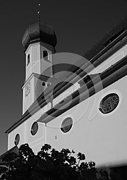 Church with onion tower snow-white facade under dark  sky in black and white