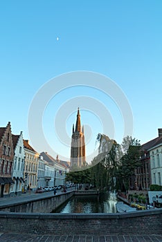 Church Of Our Lady and beautiful narrow street with canal in Bruges, Belgium