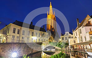 Church of Our Lady and canal illuminated in the night. Bruges, Belgium