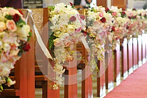Church pews decorated with bouquets