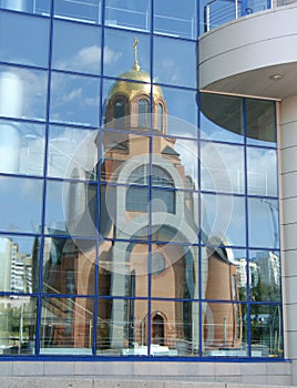 Church reflexion in windows of a modern building